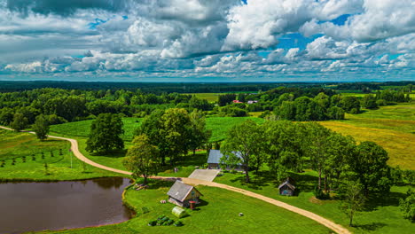 Fluffy-clouds-billowing-over-rural-farmland-fields---aerial-hyper-lapse