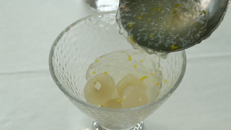 Verter-Gelatina-Sobre-Fruta-Dulce-De-Longan-En-Una-Taza-De-Postre.