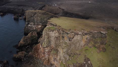 dos personas de pie en los acantilados salvajes de la costa de snæfellsnes en islandia