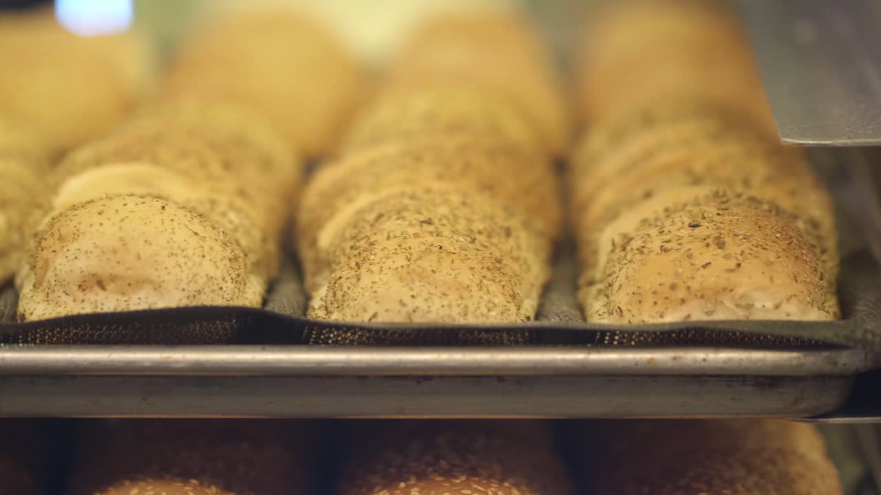 Rows of unbaked bread loaves on a baking tray