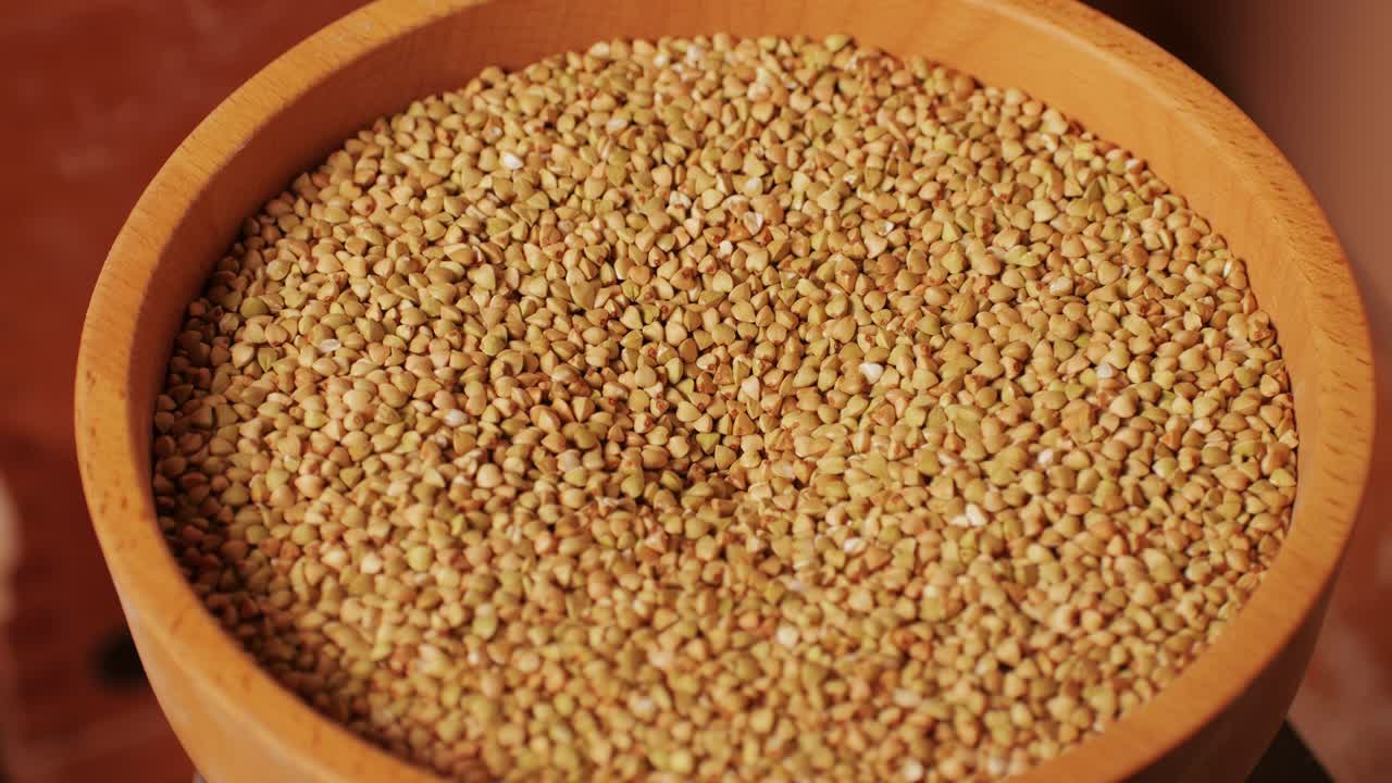 Close-up shot of treatment of seeds of cereals: rye, barley, wheat against diseases and insects using modern equipment. Hard wheat in hopper being ground into whole wheat flour. High quality 4k footage