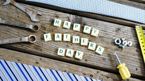 Happy-fathers-day-block-and-old-work-tool-arranged-on-wooden-plank