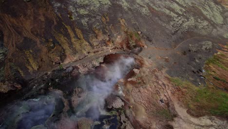 volando sobre el valle de vapor y las aguas termales geotérmicas a lo largo del reykjadalur en islandia, aérea