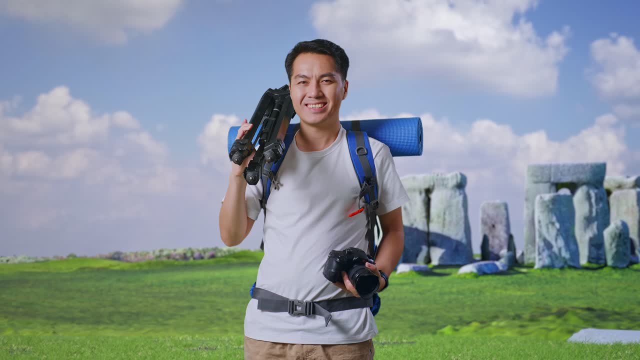 Smiling Photographer with Backpack and Tripod at Stonehenge
