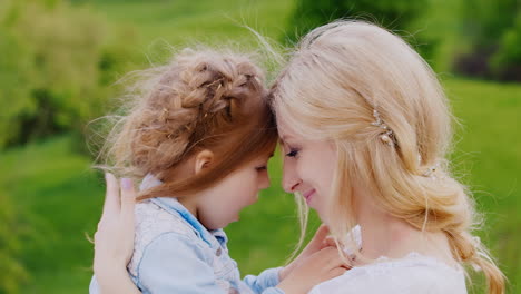 portrait of a curly blond girl and her mother tenderness care and maternal love