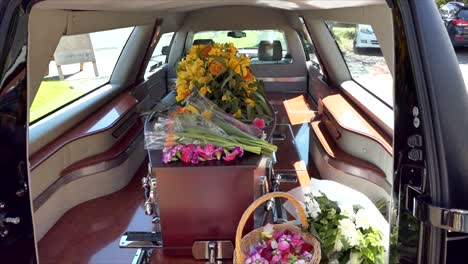 closeup shot of a funeral casket in a hearse or chapel or burial at cemetery