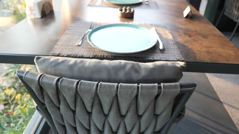 restaurant table setting with empty plates and chairs