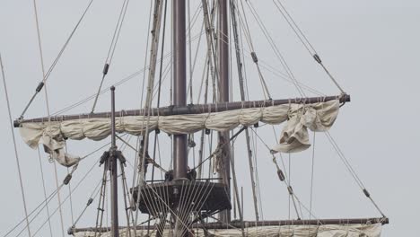 galleon andalucia replica ship with spanish flag detail tilt shot of masts and sails while docked in valencia in slow motion 60fps