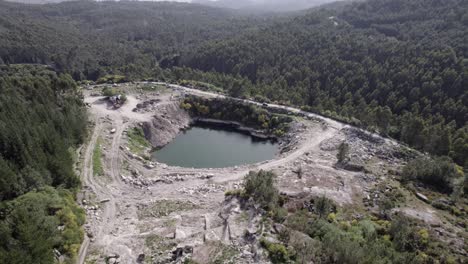 Vista-Aérea-Del-Peligroso-Drenaje-De-La-Mina-De-ácido-Tóxico-Vertido-Formando-Un-Pequeño-Estanque-De-Agua-Sucia-En-Un-Día-Soleado