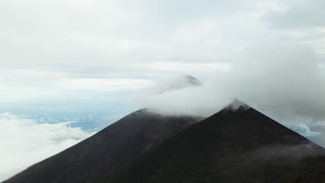 reverse dolly sobre gruesas capas de niebla o nubes goteando rodando a través de las laderas de los volcanes