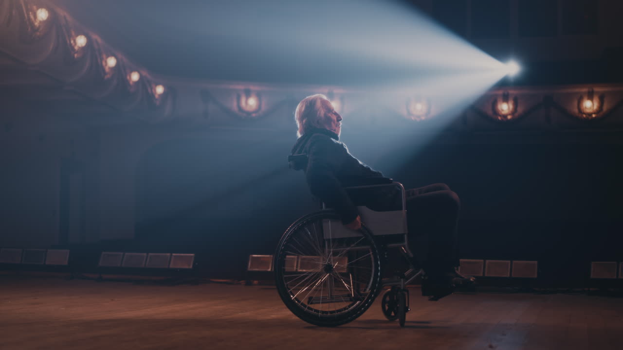 Senior Actor on Wheelchair Leaving Stage Aged Man on Wheelchair Turning Round and Leaving Stage in End of Performance in Theater
