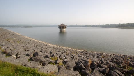 extra wide shot of carsington water carsington water valve tower, draw off tower and the dam rocks