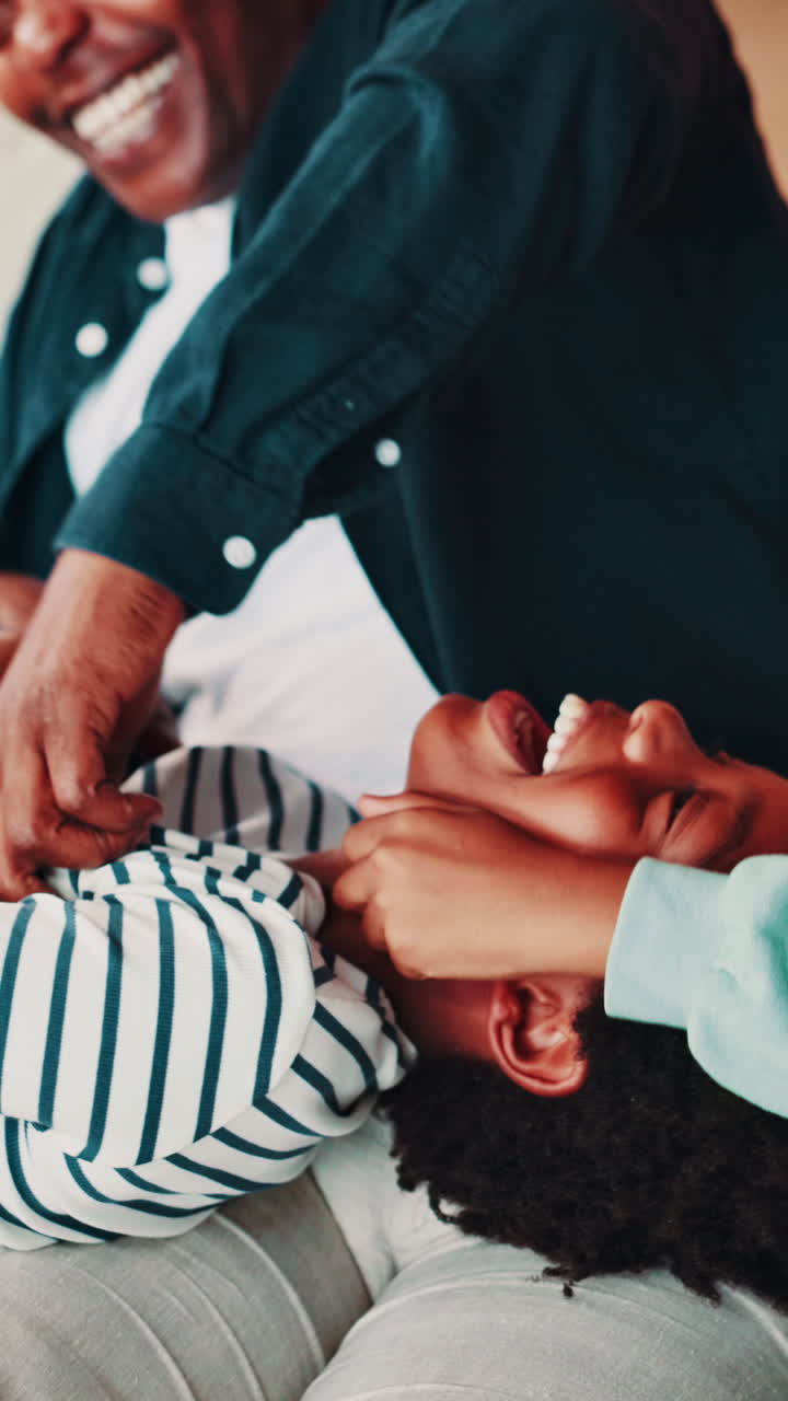 Padre felice che fa il solletico al figlio che ride a casa