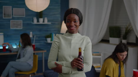 Retrato-De-Una-Mujer-Afroamericana-Sonriendo-A-La-Cámara-Mientras-Sostiene-Una-Botella-De-Cerveza