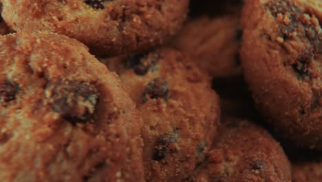 a macro close up zoom in cinematic shot of a plate full of crispy juicy chocolate chip cookies, on a rotating stand, studio lighting, slow motion, smooth movement, 4k video