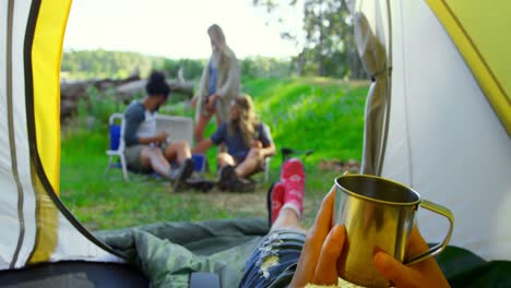 sección baja de la mujer relajándose en la tienda en el bosque 4k