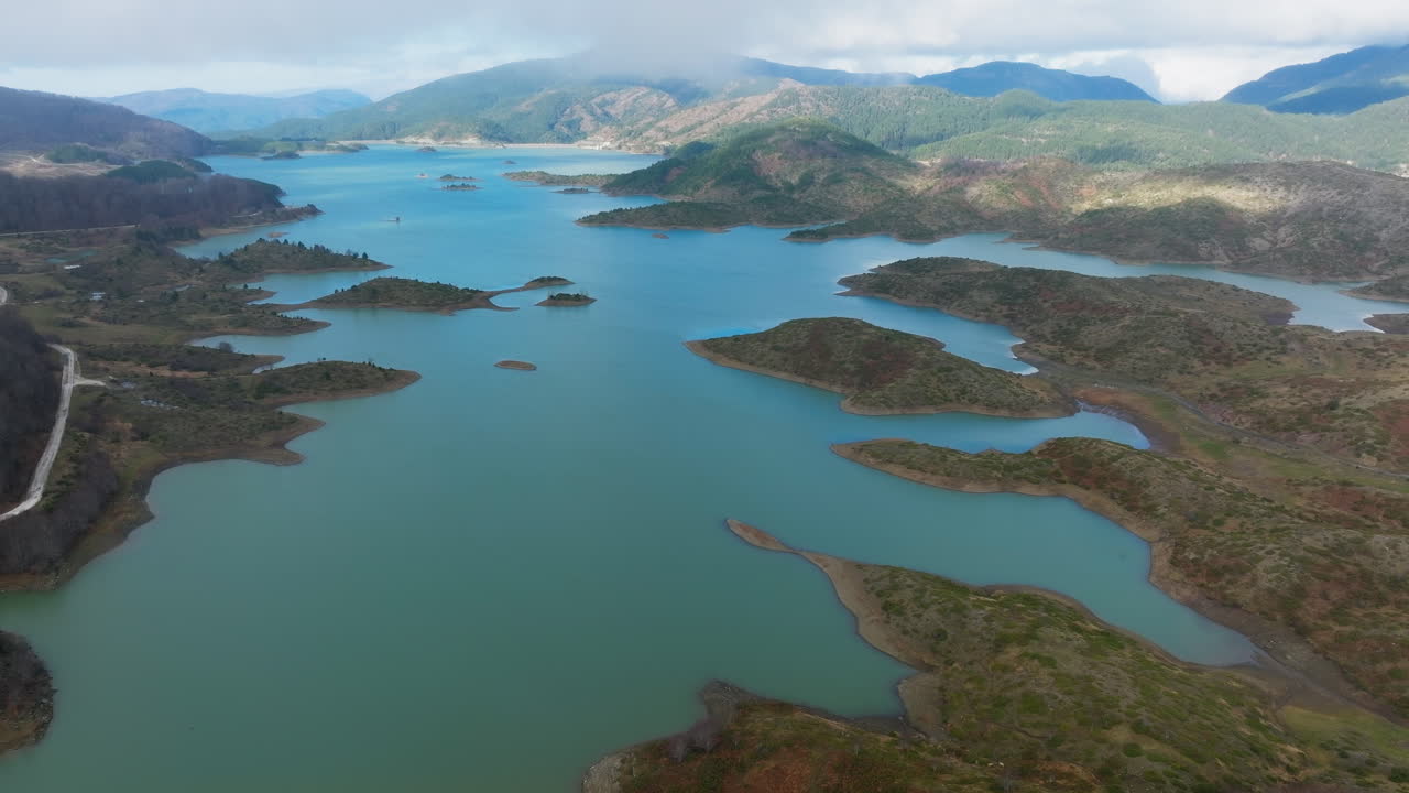 Ilhas e penínsulas no Lago das Nascentes de Aoos, Techniti Limni Aoou, Epiro, Grécia, estabelecendo uma vista aérea panorâmica.