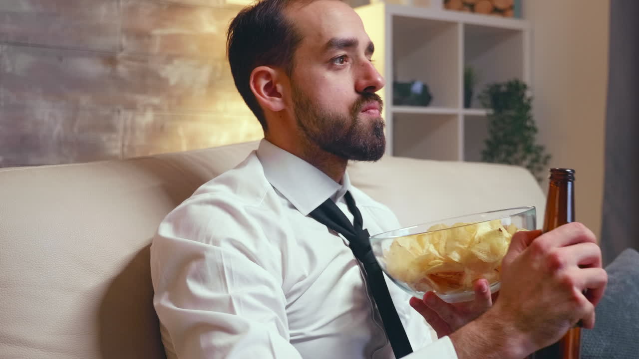 Businessman in formal wear eating chips from a bowl