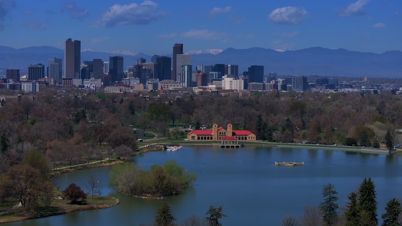 City Park Downtown Denver Colorado aerial drone springtime summer tree wildflower blossom sunny blue sky Ferril Duck Lake bike walking path green grass tall buildings skyscrapers pan left motion