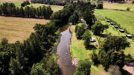 Un-Dron-Descendente-Disparó-Sobre-Un-Campamento-Rural---Gente-Flotando-Río-Abajo