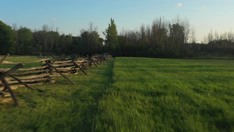 drone aerial of the fence surrounding and field near the joseph smith family farm, frame house, temple, visitors center, and the sacred grove in palmyra new york origin place of the book of mormon