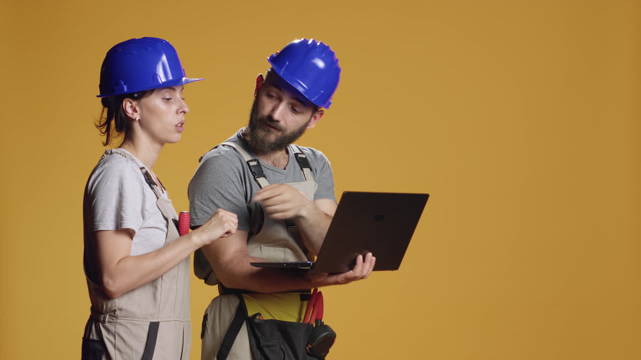 Man and woman contractors using laptop to do rebuilding measurement