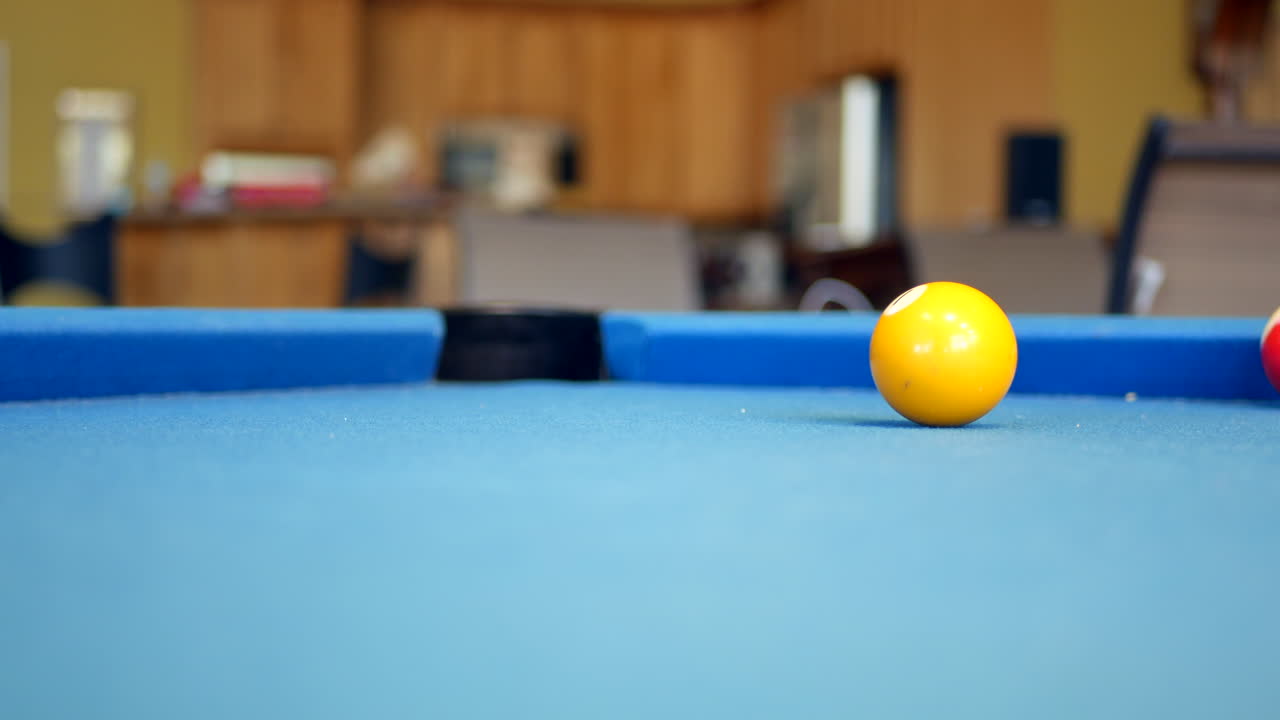 Number one pool ball rolling around on billiards table