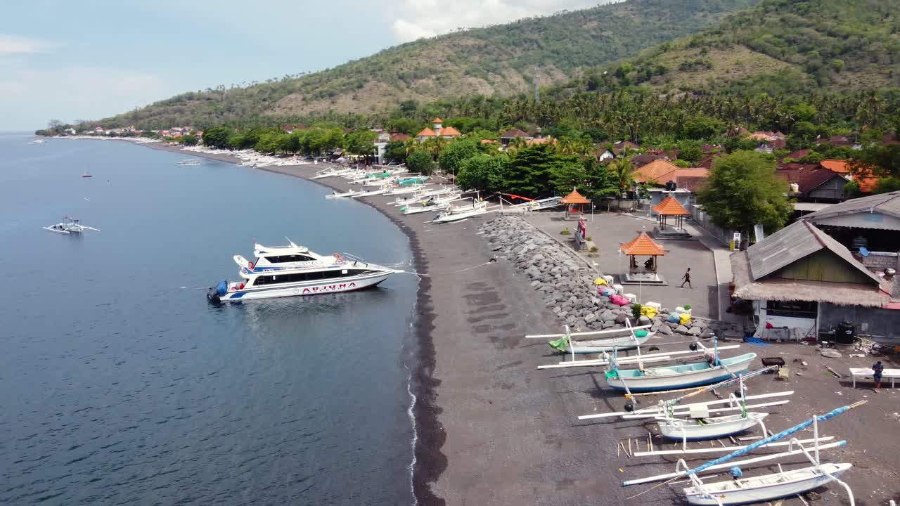 Jukung fishing boats lying on black sand beach of Amed Village in Bali - Indonesia, Aerial
