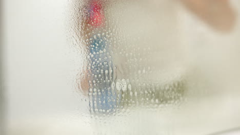a woman wiping a mirror with a cleansing sprayer while cleaning. selective focus shot
