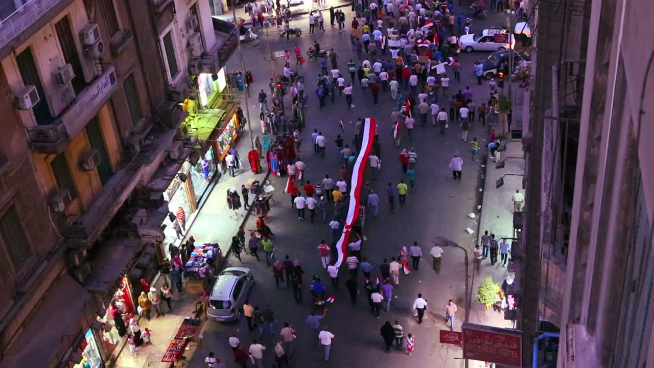 vista aérea de los manifestantes marchan y llevan pancartas en las calles de el cairo egipto por la noche