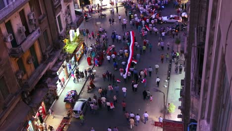 overhead view of protestors march and carry banners in the streets of cairo egypt at night