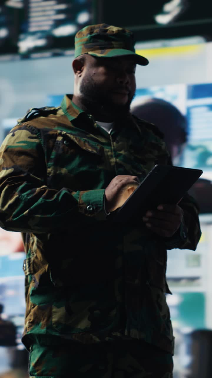 Uomo in uniforme mimetica militare che usa un tablet digitale