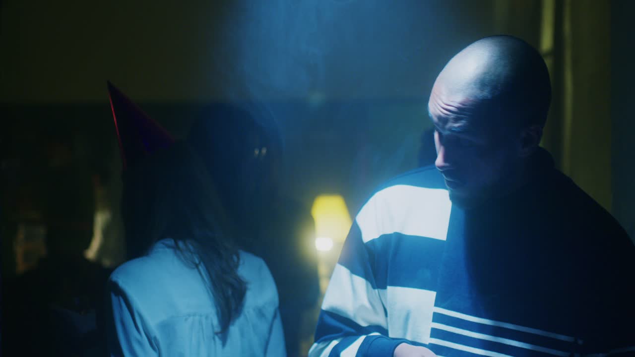 Man smokes while spotlit at party