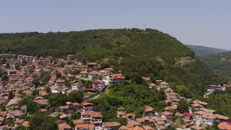 ladera de la ciudad de veliko tarnovo vuelo aéreo hacia la cima de la colina boscosa