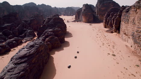 four-by-four suv's driving through the sahara desert in tassili n'ajjer national park, djanet, algeria