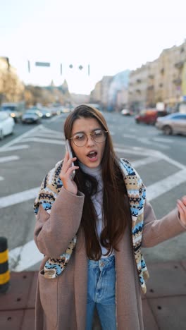 young woman talking on phone in city street