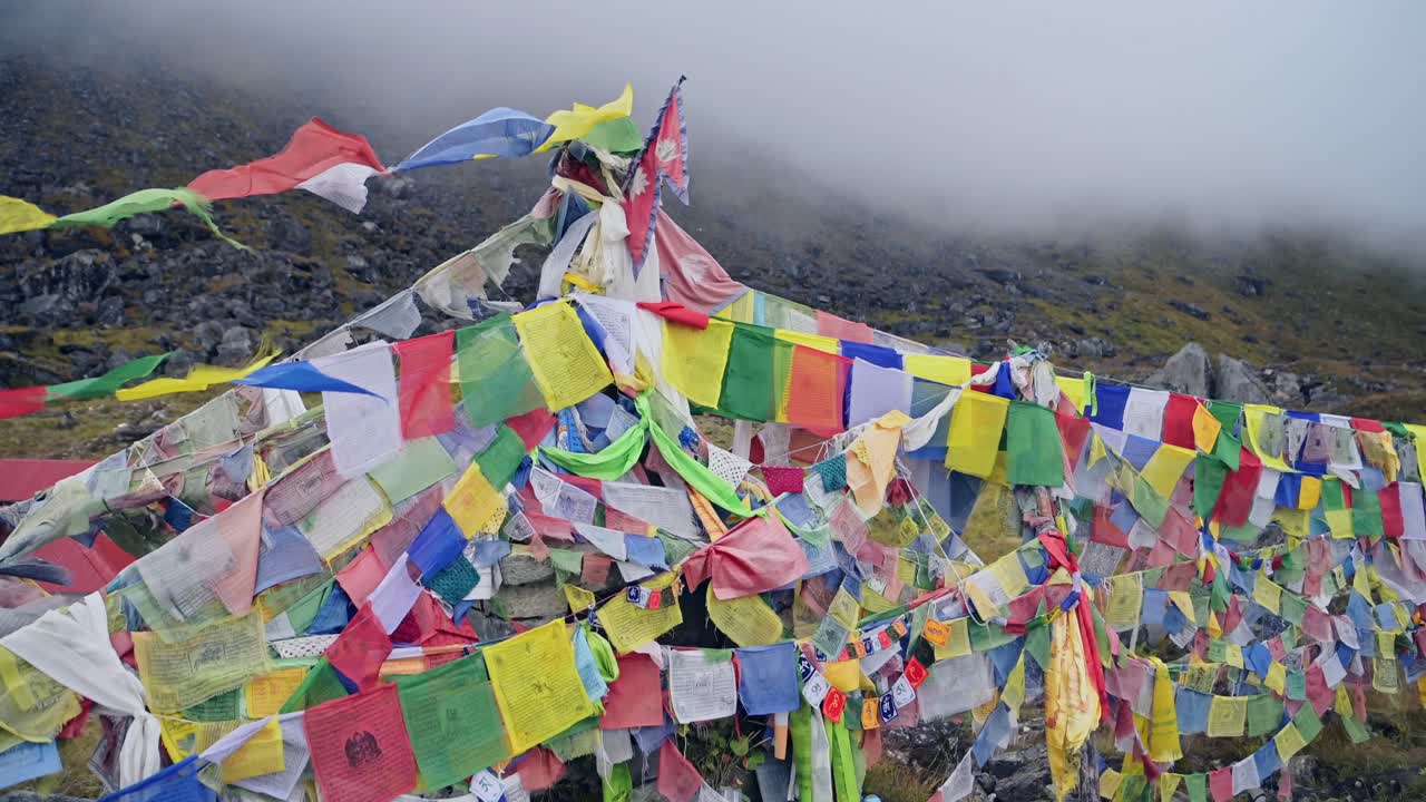 Buddhist Prayer Flags in Nepal Mountains, Colorful Tibetan Prayer Flags in Mist in the Himalayas Blowing in the Wind in Annapurna, Colourful Religious Symbol of Buddhism in Nature