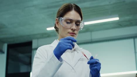 Retrato-De-La-Hermosa-Trabajadora-De-Laboratorio-Haciendo-Un-Análisis-De-Sangre-En-El-Tubo-De-Vidrio-En-Las-Manos