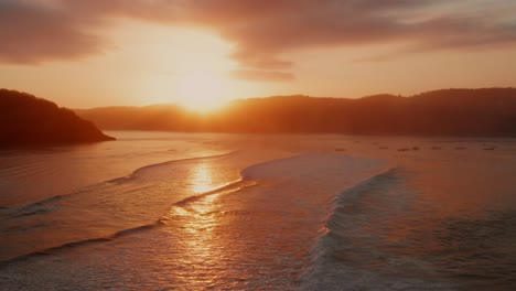 Amanecer-En-Los-Lugares-De-Surf-De-Gerupuk-En-Lombok,-Con-Vistas-A-La-Bahía-Con-Los-Barcos-De-Pesca-Y-Los-Surfistas