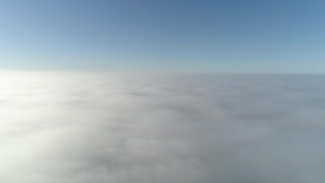 flight over misty clouds in morning sunlight with little glory and city scape under clouds