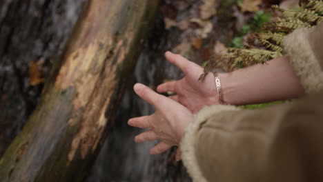 Hands-touching-water-in-running-stream