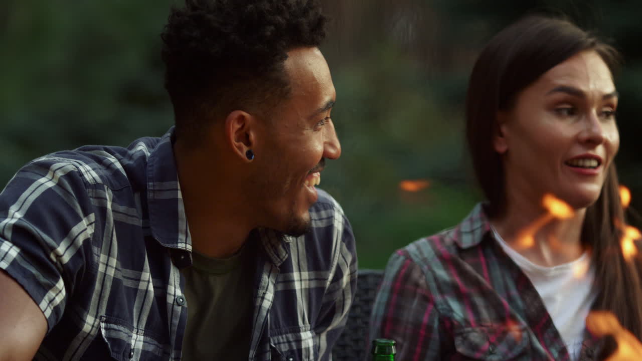 Smiling woman talking on backyard. Positive multiethnic couple laughing outdoors