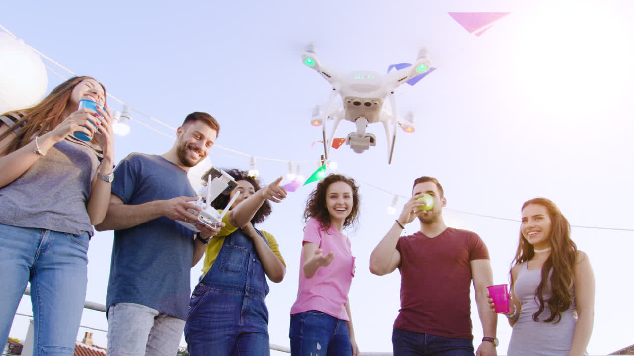 amigos celebran con drones en el techo