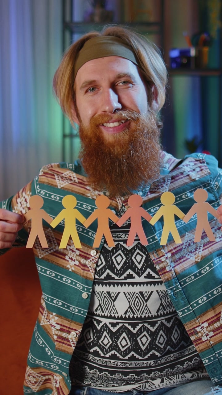 Hippie-mand viser multietniske forskellige hudfarver menneskelig form udskåret af papir mod racisme