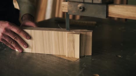 A-worker-in-the-workshop-cuts-out-a-small-bar,-shapes-it-using-electric-equipment.-Close-up-footage.-Carpenter