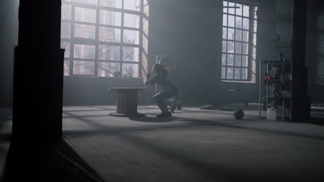 woman jumping on wooden box in gym. girl making deep squats with jumps