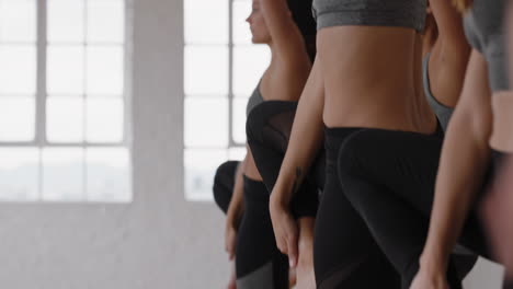 grupo de clase de yoga de hermosas mujeres multirraciales practican pose guerrera disfrutando de un estilo de vida saludable haciendo ejercicio en la meditación del gimnasio