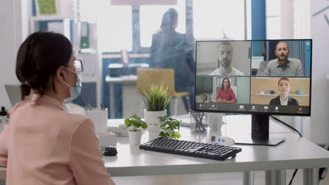 executive businesswoman with medical face mask having online videocall meeting