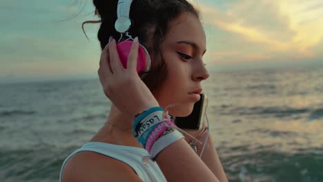 teenager girl with headphones walking on the beach. shot in slow motion