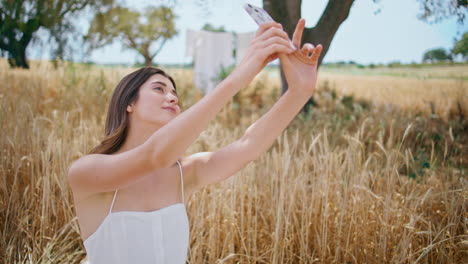 cheerful girl posing phone camera on rural nature closeup. woman making selfie